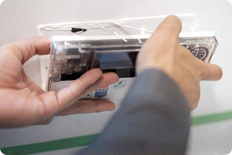 リモコンを取り外そうとしているスタッフ