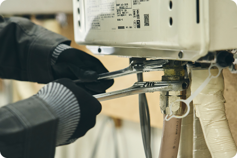 給湯器本体を撤去を撤去しようとしているスタッフ